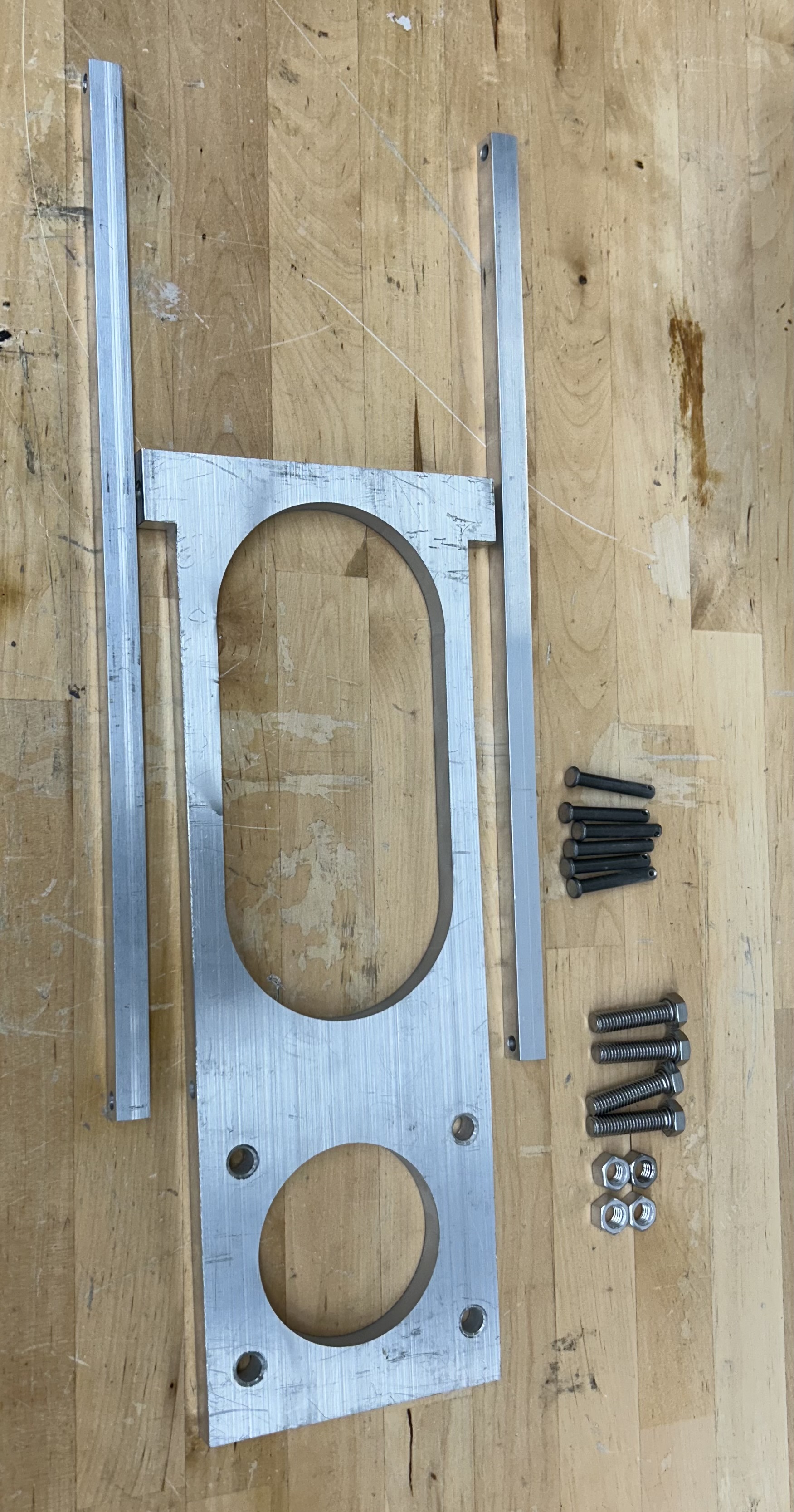 The image shows the all the parts we designed or selected. The platform and arms were machined out of AL6061 to balance weight and strength needs. The pins underwent a high shear stress, so a steel alloy (AISI 4140) was selected for its high strength.